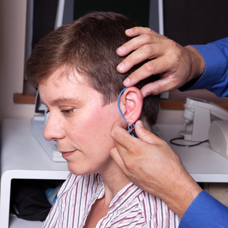 Audiologist performing a real ear measurement.