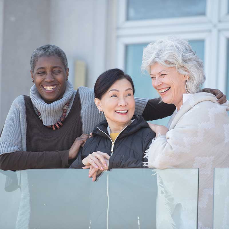 Multi-racial group of friends laughing on a balcony
